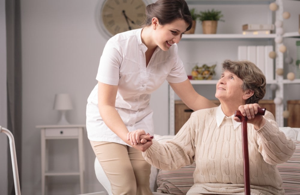 Young Caregiver Supporting a Senior Woman